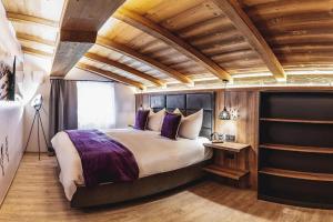 a bedroom with a large bed and wooden ceilings at Chalet Amadeus by we rent in Piesendorf