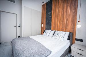 a bedroom with a bed with white sheets and pillows at Nad Zatoką Apartament 132 by Warmia4Rent, przy samej plaży miejskiej in Olsztyn