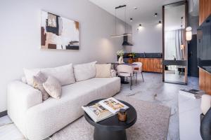 a living room with a white couch and a table at Nad Zatoką Apartament 132 by Warmia4Rent, przy samej plaży miejskiej in Olsztyn