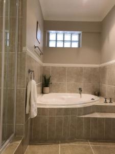 a bathroom with a tub and a shower at Spacious sunny secure and central with scenic views in Hout Bay +48 photos