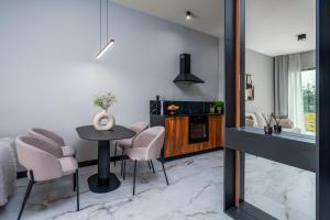 a kitchen and living room with a table and chairs at Nad Zatoką Apartament 132 by Warmia4Rent, przy samej plaży miejskiej in Olsztyn