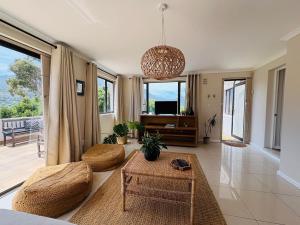 a living room with a couch and a table at Spacious sunny secure and central with scenic views in Hout Bay