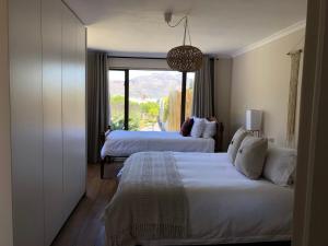a hotel room with two beds and a window at Spacious sunny secure and central with scenic views in Hout Bay