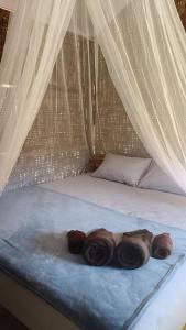 a bed with three logs laying on a blue blanket at Mook Mellow Hill Bungalows in Ko Mook +28 photos