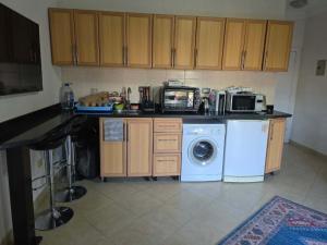 a kitchen with a washing machine and a microwave at Pool & Beach Apartment in Sharm El Sheikh
