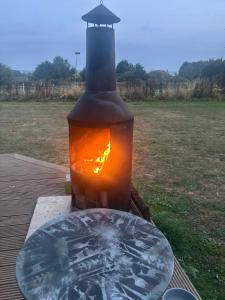 a wood fired stove with a glass table in a field at Yellowhammer Hut at Carr House Farm in Cayton