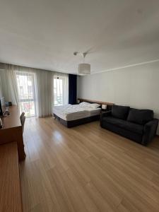 a bedroom with a bed and a couch and a desk at Оrbi Palase Deluxe in Bakuriani +32 photos