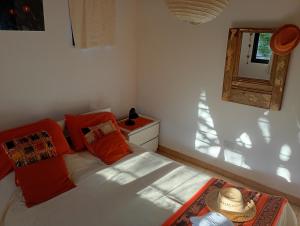 a bedroom with a bed with orange pillows and a window at Arcadia in Merlo