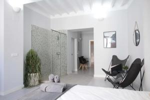 a bedroom with white walls and a bed and chairs at Jome Stays La Nucía in La Nucía