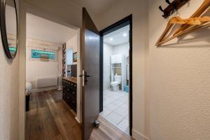 a hallway with a bathroom with a toilet and a door at le Thermal 108 in Saint-Martin-d'Uriage