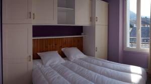 a large bed in a room with a window at LILOA in La Bourboule