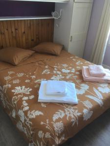 a bed with two towels and a tray on it at LILOA in La Bourboule +4 photos