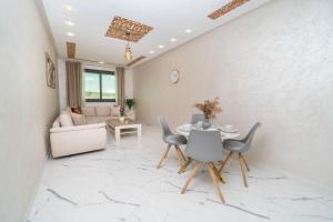 a living room with a table and chairs at Luxury Abraj YK 120m2 in Tangier