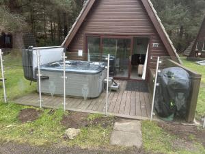 a hot tub on a deck in front of a house at Bright Star Lodge in Spean Bridge +45 photos