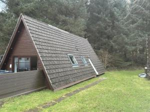 a house with a gambrel roof with two windows at Bright Star Lodge in Spean Bridge