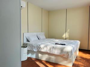 a bedroom with a white bed with a book on it at NeOtel Apartments in Ban Saiyuan (1) +37 photos