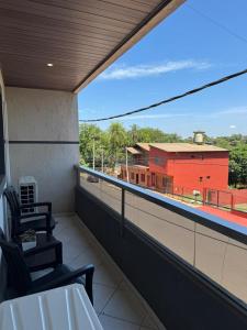 a balcony with chairs and a view of a building at Santino Apart in Puerto Iguazú