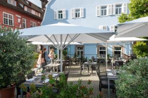 a patio with tables and umbrellas in front of a blue building at Bachofer in Waiblingen