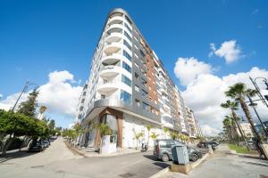 a tall building with a car parked in front of it at Luxury Abraj YK 120m2 in Tangier