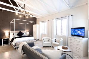 a bedroom with a bed and a couch and a tv at Hilton Cottage in Hilton