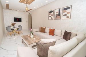 a living room with a white couch and a table at Luxury Abraj YK 120m2 in Tangier
