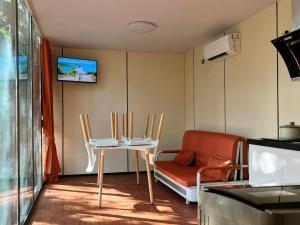 a living room with two chairs and a table and a tv at NeOtel Apartments in Ban Saiyuan (1)