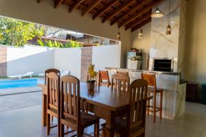 a dining room with a wooden table and chairs at Casa Dos Papagaios in Bonito