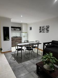 a living room with a table and chairs and a kitchen at Santino Apart in Puerto Iguazú