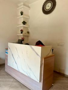 a marble counter in a room with a clock on the wall at Mayama Residences in Accra