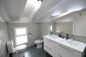 a bathroom with a sink and a toilet and a window at Jome Stays La Nucía in La Nucía