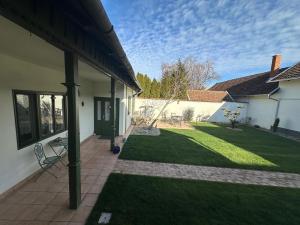 a backyard with a lawn and a house at Casa Eloria in Békéscsaba
