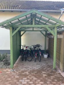 a group of bikes parked under a green garage at Casa Eloria in Békéscsaba