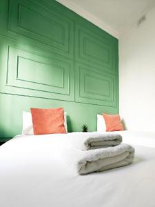 a bedroom with a large white bed with orange pillows at Cosy room 7 in Tal-Pietà