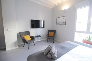 a bedroom with two chairs and a bed and a tv at Jome Stays La Nucía in La Nucía