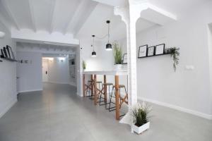 a kitchen with white walls and a table with stools at Jome Stays La Nucía in La Nucía