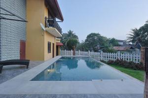 a swimming pool in a yard next to a house at Canal's Edge in Negombo