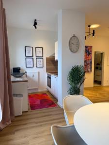 a kitchen with a table and a clock on a wall at Heinsberg City Apartment - Stil trifft Farbe! in Heinsberg