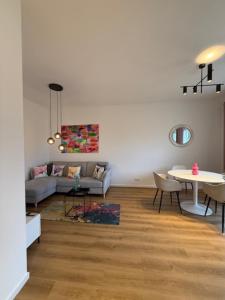 a living room with a couch and a table at Heinsberg City Apartment - Stil trifft Farbe! in Heinsberg