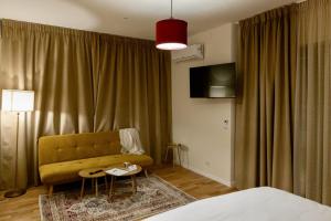 a hotel room with a couch and a table at Habitat Suites - Modern Apartments with Terraces and Free Parking in Craiova