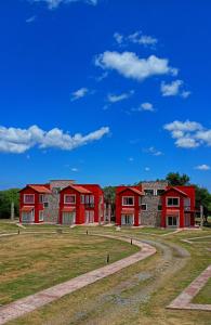 a row of red houses on a grass field at Alma Apart in Los Molles