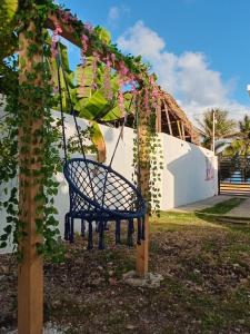 a swing in front of a building with vines at Villa el real los patos in Los Patos
