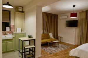 a hotel room with a couch and a sink and a kitchen at Habitat Suites - Modern Apartments with Terraces and Free Parking in Craiova