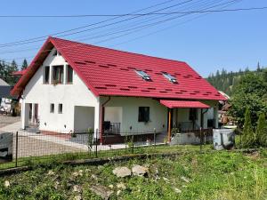 a small white house with a red roof at Căsuța din Vale in Voronet