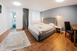 a bedroom with a bed and a desk and a table at Căsuța din Vale in Voronet