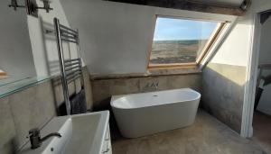 a bathroom with a tub and a sink and a window at School House in Reeth