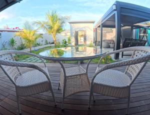 a glass table and two chairs on a deck at Ranbin Retreat in Manadhoo