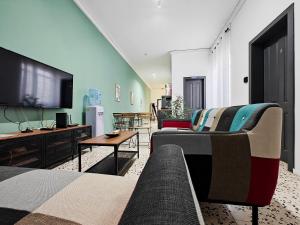 a living room with a couch and a flat screen tv at Cosy room 7 in Tal-Pietà