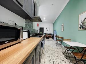 a kitchen with a counter and some tables and chairs at Cosy room 7 in Tal-Pietà +17 photos