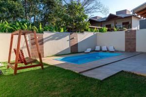 a backyard with a swing and a pool at Casa Dos Papagaios in Bonito