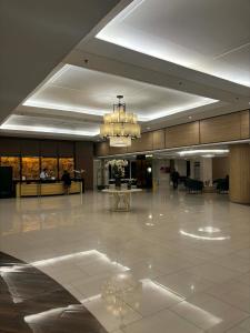 a large lobby with a chandelier in a building at Shell Residences Tower A B in Manila +24 photos